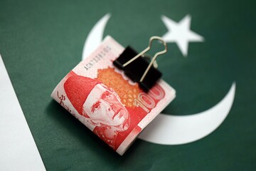 Pakistan rupees banknotes on Pakistani flag. The current Pakistan money bills