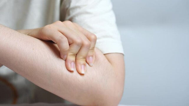Young Asian woman massaging her upper arm with gentle pressure showing self treatment for muscle tension and promoting body awareness