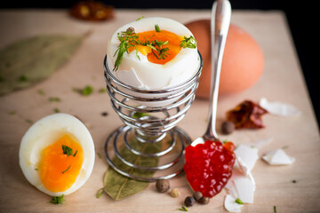 delicacy with red caviar and boiled egg for breakfast, on a wooden board