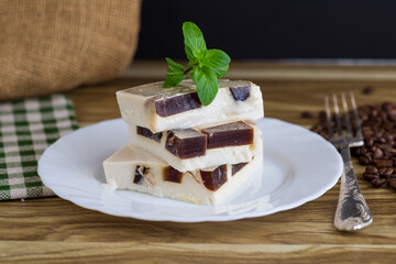delicate milky coffee jelly in a plate with a sprig of mint