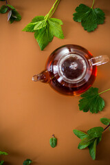 Natural tea from currant leaves and mint on brown background