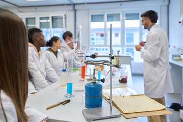 Chemistry teacher explaining lesson to students in laboratory