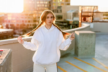 Generation z teenager posing on parking garage rooftop at sunset