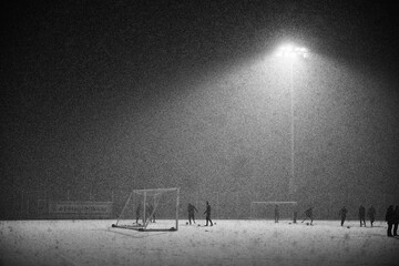 Soccer players training under heavy snowfall at night