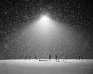 Soccer players training under heavy snowfall at night