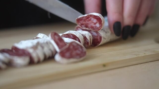 Woman slicing fuet salami in close-up. Popular gourmet treat. Czech Republic