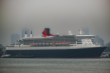 Luxury ocean liner cruiseship cruise ship Queen Mary docked at terminal in Brooklyn on grey rainy...