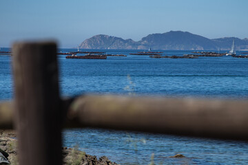 Wooden boardwalk on the beach with the Cies Islands, Galicia, Spain in the background