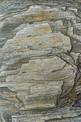 Fototapeta premium A close-up view of a gray stone surface reveals intricate layers and patterns, illustrating natural geological processes over time.