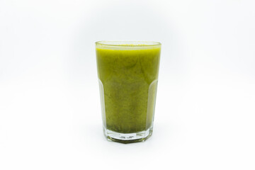 Front view of green smoothie served in transparent glass placed on white background showing creamy...