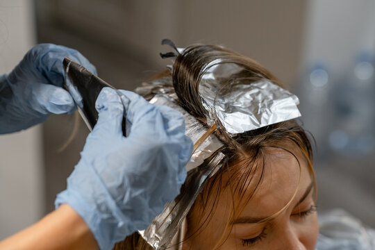 Hair coloring process with foils in a bright salon during a daytime session