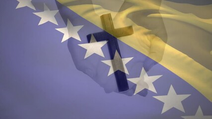 Waving Bosnian flag starting hands gripping wooden cross, symbolizing ongoing national faith
