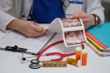 A dedicated medical professional meticulously analyzing tumor scans and medications in a clinical...