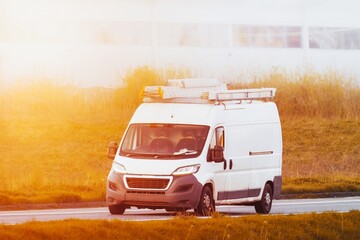 Professional van carrying equipment and ladder on the road