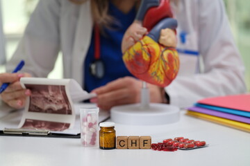 A dedicated medical professional studies heart health and CHF management using a heart model and medications