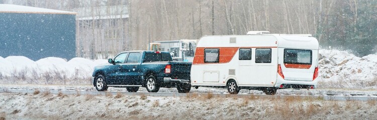 Black pickup with caravan snowy travel day © AlexGo