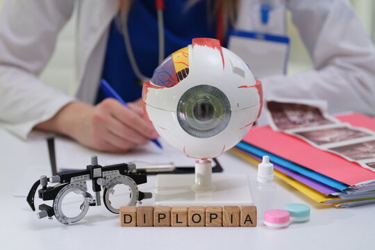 Medical tools for diagnosing diplopia, featuring eye model, optometry equipment, and health documents.