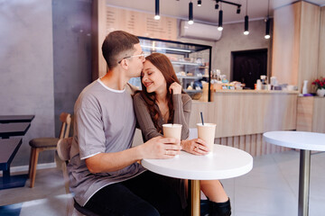 Young couple enjoys intimate moment with coffee in cozy cafe during afternoon
