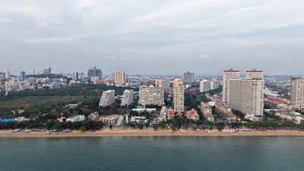Modern buildings rising along the pattaya coastline create a stunning cityscape against the ocean backdrop as twilight approaches, blending urban development with natural beauty