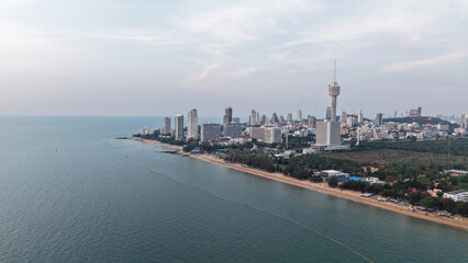 Modern buildings rising along the pattaya coastline create a stunning cityscape against the ocean backdrop as twilight approaches, blending urban development with natural beauty