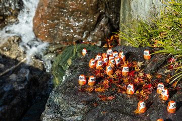 Scenic view of Katsuoji Temple in Minoh during peak autumn season. Beautifully framed by vibrant red and orange maple leaves, reflecting the serene atmosphere of autumn.