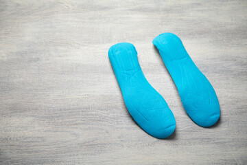Shoe insole on the white wooden background.