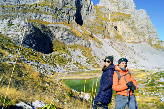 Couple's leisure time together: active recreation in nature. Happy man and woman during hiking in Prokletije National Park: visiting Buni Jezerce location in Albania. Two tourists in the mountains.