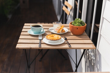 English chicken mushroom pie with coffee cup on wooden table at cafe outdoors.