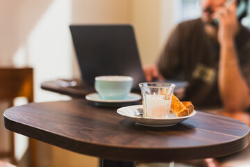 Breakfast half cooked boiled with slice of toast with man working in background.