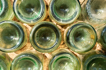 The bottoms of green bottles are photographed from above. The image captures the circular shapes...