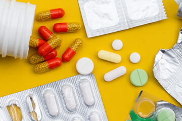 Close-up of various pills and tablets and blister packs on yellow background, healthcare and...