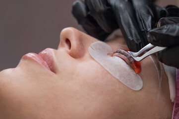 Caucasian woman undergoing eyelash lamination procedure. 