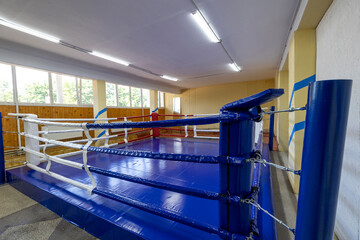 Professional boxing ring with padded ropes and a sturdy canvas surface, set up in a dedicated...