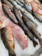 Fresh gutted fish displayed on crushed ice at a seafood market, ready for sale or cooking...