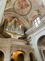 View of a beautiful golden pipe organ inside a large church, showcasing intricate details and...