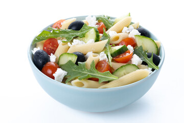 Mediterranean Pasta Salad in bowl with Fresh Vegetables and Herbs isolated on white background.