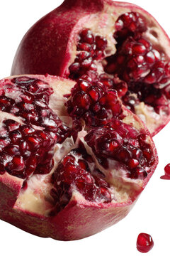 Pomegranate's Ruby Elegance: a detailed shot of a juicy pomegranate, ripe and bursting, revealing its vibrant, ruby-red seeds. It's a close-up on freshness and deliciousness.