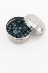 contenitore in acciaio inossidabile per alimenti con mirtilli freschi su sfondo bianco