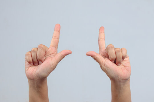 Both hands forming L shape gesture with thumb and index finger raised
