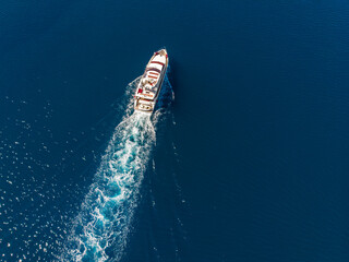Top above aerial drone view luxury motor yacht sailing in turquoise blue sea water Mediterranean landscape background on sunny summer day.  Motor boat ship charter rental trip insurance