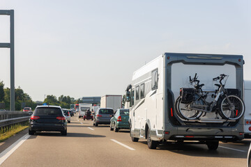 Back tail view of many cars stuck in row at highway road traffic jam cold overcast rainy winter day at Europe. Automobile accident vehicle rush hour collapse. Transportation vacation seasonal stuck