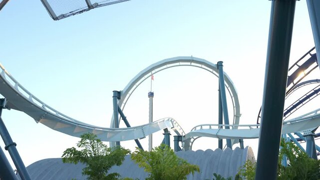 Riders scream in delight as they navigate twists and turns on the thrilling roller coaster. The clear sky amplifies the joy of the amusement park experience at Sea World.