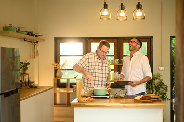 Father and adult son sharing laughter while cooking in a cozy home kitchen. Fathers day concept