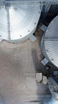 Steel big grain elevators. Industrial grain storage tanks. Arrial view. Vertical video