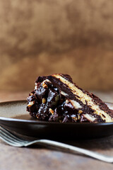 Piece of Chocolate Cake on a Plate. Rustic stone background. Copy space.	
