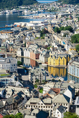 View of downtown of Alesund in Norway, with its colorful Art Nouveau buildings along the brosundet Canal and the sea in background in a sunny day