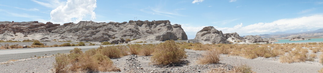 Panorama of street, rocks and lake in Andes desert, San Juan province, Argentina.