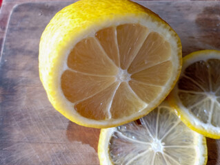 vibrant yellow lemon, sliced in half, revealing its juicy interior and seeds, against a soft,...