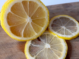 vibrant yellow lemon, sliced in half, revealing its juicy interior and seeds, against a soft,...