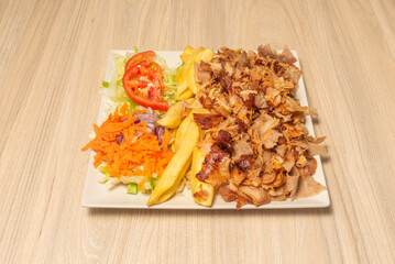kebab plate with shredded grilled chicken and lamb and chips.